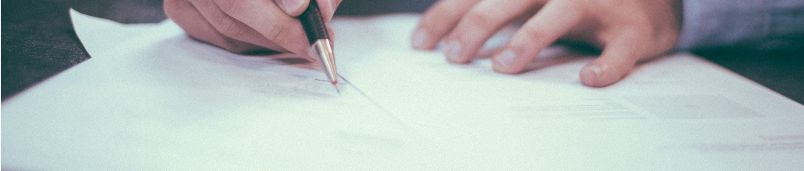 Hands signing a document