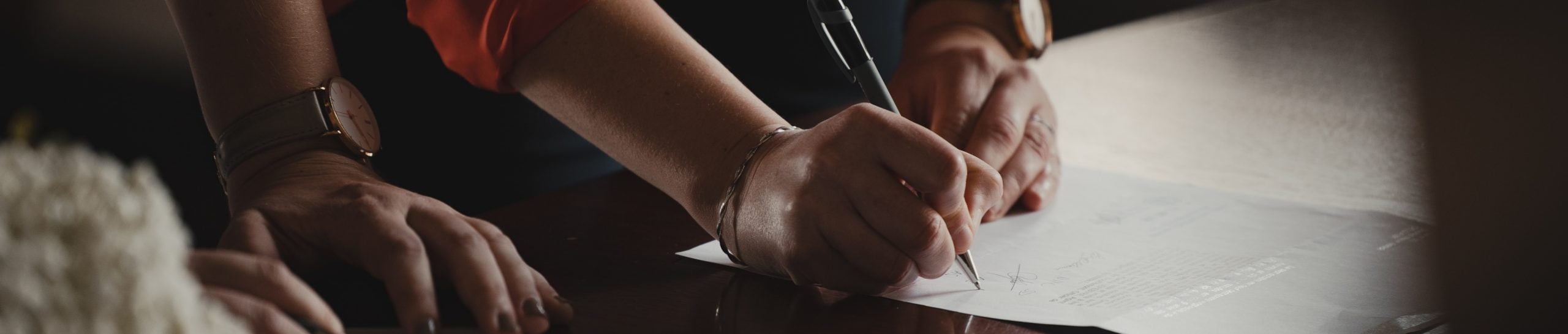 Hands writing on documents